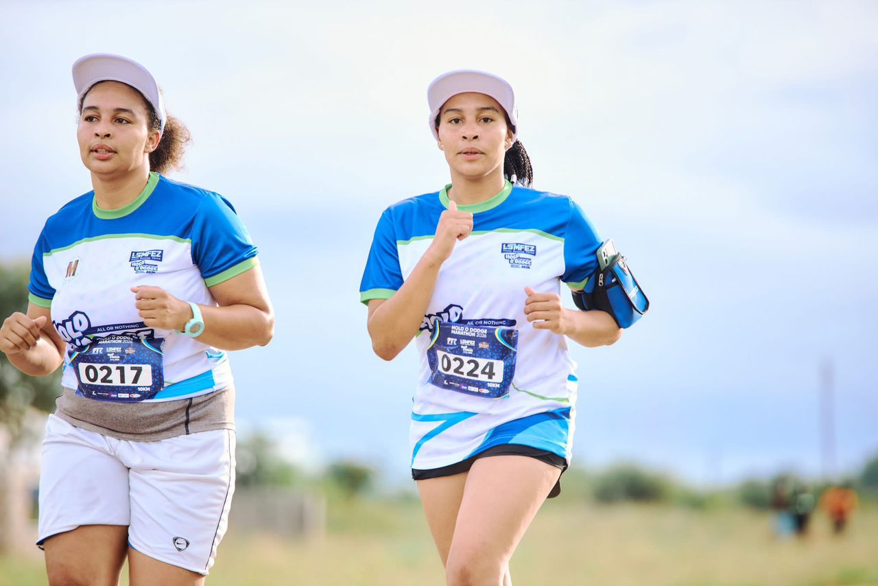 Two women running side by side in race jerseys